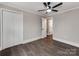 This bedroom has a ceiling fan, closet, and grey wood-look flooring at 412 Pear St, Gastonia, NC 28054
