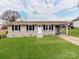 Charming single-story home with a well-maintained lawn, inviting entrance, and convenient carport at 412 Pear St, Gastonia, NC 28054