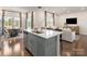 Bright open-concept kitchen with large island, stainless steel appliances, and adjacent dining/living area at 459 Olympia Way, York, SC 29745
