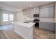 Modern kitchen island with stainless steel appliances, light gray cabinets and wood flooring at 459 Olympia Way, York, SC 29745