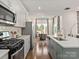 Modern kitchen featuring stainless steel appliances, white cabinets, an island, and hardwood floors at 459 Olympia Way, York, SC 29745