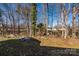 Backyard featuring mature trees, a fire pit, and natural surroundings at 4642 Willow Glen Rd, Harrisburg, NC 28075