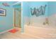 Relaxing bathroom featuring a tub, separate glass shower, and themed decorations at 4642 Willow Glen Rd, Harrisburg, NC 28075