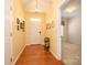 Bright foyer featuring hardwood floors, warm-colored walls, decorative lighting, and an open doorway to another room at 4642 Willow Glen Rd, Harrisburg, NC 28075