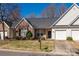 Charming brick and siding townhome with attached garage, neat landscaping, and a well-maintained lawn on a sunny day at 4642 Willow Glen Rd, Harrisburg, NC 28075