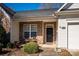 Inviting front porch featuring brick accents, a black front door with a gold number plate, and neat landscaping at 4642 Willow Glen Rd, Harrisburg, NC 28075