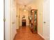 Hallway with wood floors, light yellow walls, multiple doors, decorative cabinet, a desk, and elegant lighting at 4642 Willow Glen Rd, Harrisburg, NC 28075