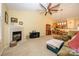 Open living area featuring a fireplace, vaulted ceilings, a ceiling fan, view into the kitchen, and comfortable furniture at 4642 Willow Glen Rd, Harrisburg, NC 28075