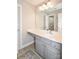 Neutral toned bathroom with a gray vanity, ample lighting and a decorative rug at 4812 Campobello Dr, Monroe, NC 28110