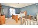 Bedroom with blue accent wall and a cozy wooden crib at 4812 Campobello Dr, Monroe, NC 28110