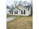 Charming one-story home with neutral siding, black shutters, a well-maintained lawn and a paved driveway at 5702 Burning Ridge Dr, Monroe, NC 28110