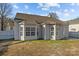 The backyard features a well-maintained lawn, and views of a white fence line with mature trees beyond at 5720 Parkstone Dr, Matthews, NC 28104