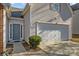 Two-story home featuring a front entry door, a white garage door and manicured front yard landscaping at 5720 Parkstone Dr, Matthews, NC 28104