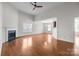 A cozy living room area with a fireplace, a ceiling fan and hardwood floors at 5720 Parkstone Dr, Matthews, NC 28104