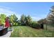 Spacious backyard featuring green grass, mature trees, and privacy shrubs at 6112 Canyon Trl, Denver, NC 28037