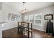 Bright dining area with a rustic table set, shuttered windows, and modern lighting at 6112 Canyon Trl, Denver, NC 28037