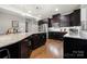 This modern kitchen is equipped with stainless steel appliances, dark cabinets, and a large island at 6112 Canyon Trl, Denver, NC 28037