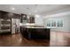 Modern kitchen featuring dark cabinetry, stainless steel appliances, and a large island with granite countertops at 6112 Canyon Trl, Denver, NC 28037