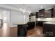 Open kitchen boasts a large island with granite countertops, stainless steel appliances, and dark cabinetry at 6112 Canyon Trl, Denver, NC 28037
