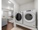 Laundry room with modern washer and dryer units, with a glimpse into the nearby living room at 6112 Canyon Trl, Denver, NC 28037