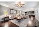 Open-concept living room with hardwood floors, ceiling fan, and seamless flow into the modern kitchen at 6112 Canyon Trl, Denver, NC 28037