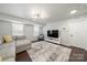Living room featuring plantation shutters, hardwood floors, and grey couch at 6112 Canyon Trl, Denver, NC 28037