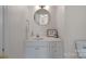 Clean half bathroom with modern fixtures, a round mirror, and stylish decor at 653 Camrose Ne Cir, Concord, NC 28025