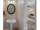 Cozy half-bathroom with pedestal sink and decorative mirror at 653 Camrose Ne Cir, Concord, NC 28025