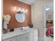 Chic bathroom with a white vanity, round mirror, and modern lighting fixtures at 653 Camrose Ne Cir, Concord, NC 28025