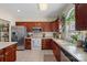 Traditional kitchen features stainless steel appliances, dark wood cabinets, and ample counter space at 653 Camrose Ne Cir, Concord, NC 28025