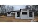 Angle of a modern home with white siding and black window trim on a cloudy day at 6855 Union Rd, Gastonia, NC 28056