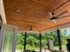 Outdoor patio with wood ceiling, recessed lighting, and ceiling fans overlooking a wooded area at 6855 Union Rd, Gastonia, NC 28056