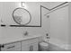 Clean bathroom with a tub-shower combo, round mirror, subway tiles and modern fixtures at 85 Grove Nw Ave, Concord, NC 28025