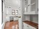 Open kitchen area with hardwood floors, stainless steel appliances, white cabinets and eat-in area at 85 Grove Nw Ave, Concord, NC 28025