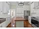 Bright kitchen featuring stainless steel appliances, wooden island, and white cabinets with tile backsplash at 85 Grove Nw Ave, Concord, NC 28025