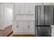 Modern kitchen featuring white cabinets, subway tile backsplash, stainless steel refrigerator, and hardwood floors at 85 Grove Nw Ave, Concord, NC 28025