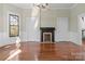 Open living room area featuring hardwood floors, fireplace, wainscoting and a window with natural light at 85 Grove Nw Ave, Concord, NC 28025
