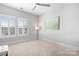 Bright bedroom featuring neutral carpet and paint, a ceiling fan, and shuttered windows allowing ample light at 9223 Robbins Preserve Rd, Cornelius, NC 28031
