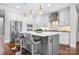 Open kitchen with a large island, modern lighting, stainless steel appliances, and bar stool seating at 9223 Robbins Preserve Rd, Cornelius, NC 28031