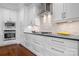 Modern white kitchen with stainless steel appliances and stylish backsplash at 9223 Robbins Preserve Rd, Cornelius, NC 28031