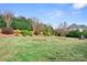 Expansive backyard with lush lawn, manicured hedges, and mature trees offers privacy and tranquility at 9223 Robbins Preserve Rd, Cornelius, NC 28031