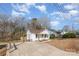 Exterior view of the charming house featuring a long driveway and beautiful mature trees surrounding the property at 1003 Harris St, Kannapolis, NC 28081