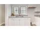Bright kitchen featuring white cabinets, granite countertops, and a stainless steel sink at 1003 Harris St, Kannapolis, NC 28081
