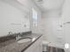Bright bathroom with vanity with granite counter, white cabinets and tub shower combo at 1211 Pine St # A, Mooresville, NC 28115