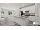 The kitchen with island features granite countertops and stainless steel appliances, and opens to the living area at 1211 Pine St # A, Mooresville, NC 28115