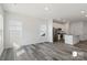 Open-concept living room with hard surface floors leads to a modern kitchen featuring stainless steel appliances at 1211 Pine St # A, Mooresville, NC 28115