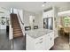 Open-concept kitchen with granite island and stainless steel appliances adjacent to the carpeted stairs at 16404 Mckee Ridge Dr, Charlotte, NC 28278