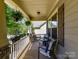 Cozy porch with chairs, table, and hanging plants, perfect for enjoying the outdoors at 16404 Mckee Ridge Dr, Charlotte, NC 28278