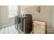 Charming laundry room with tile flooring, modern washer and dryer, and functional shelving at 2125 Partridge Berry Ln, Rock Hill, SC 29730