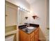 Bathroom with single sink, wood cabinet, and a mirror with bright lighting at 2623 Shaw Ave, Gastonia, NC 28054